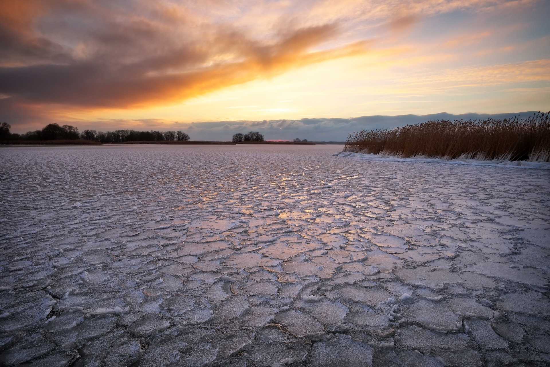 凍りついた湖と夕焼け空　冬の風景