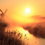 伝統的な風車と春の霧の運河　オランダの日の出の風景