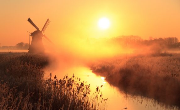 風車と運河と春の霧の風景　オランダの日の出の風景