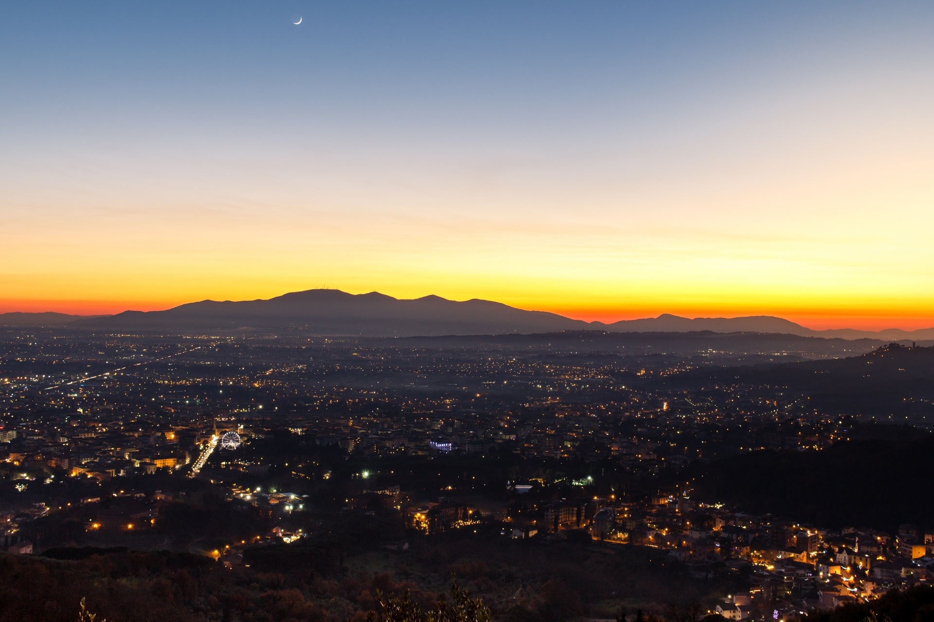 夕日とトスカーナの街明かりの風景　イタリアの風景