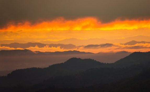 朝焼けに染まる夏の朝の空と山々　タイの風景