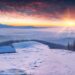 雪に覆われた山々のカラフルな冬の日の出の風景